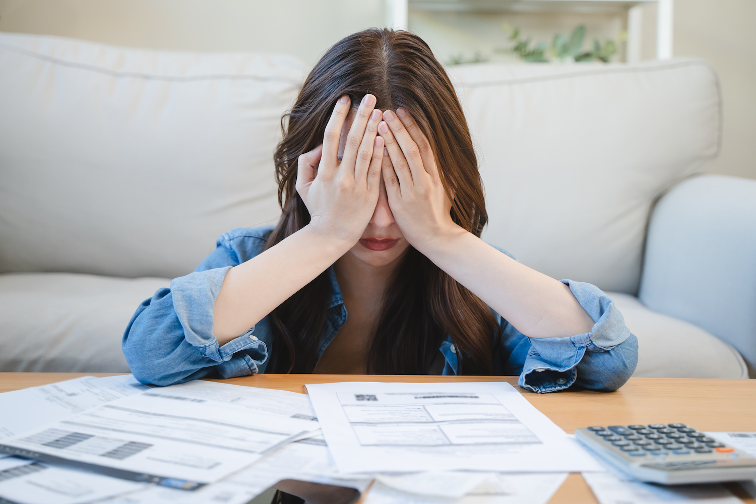 person overwhelmed by unpaid bills