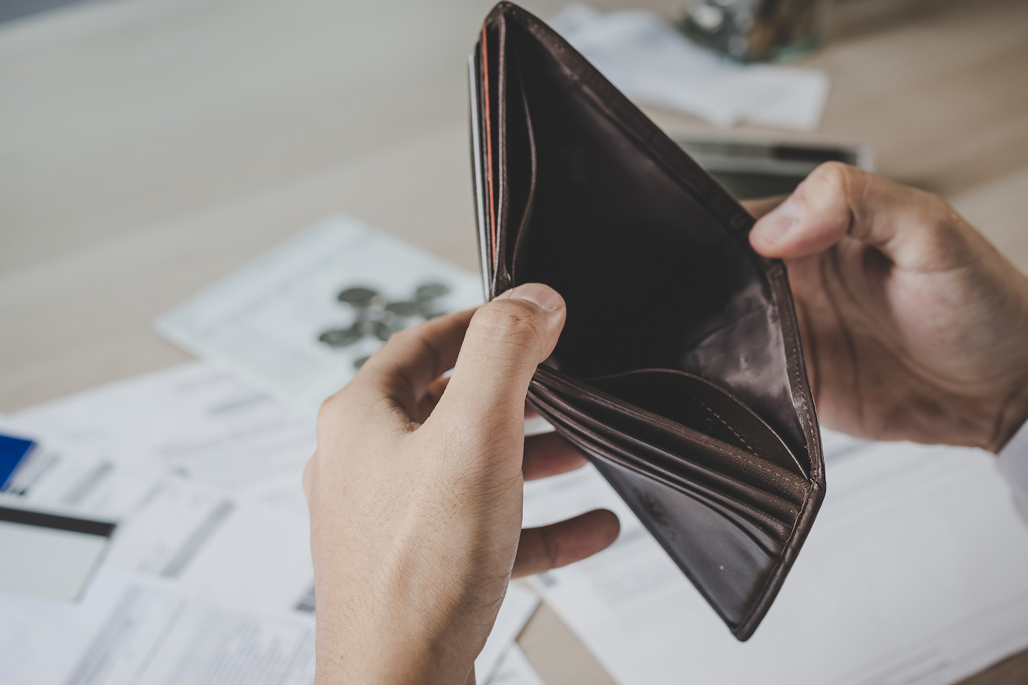 person looking inside an empty wallet