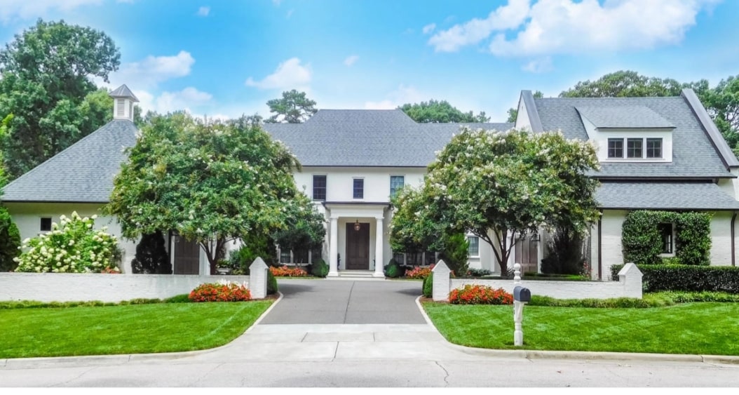 Large home with white wall around it